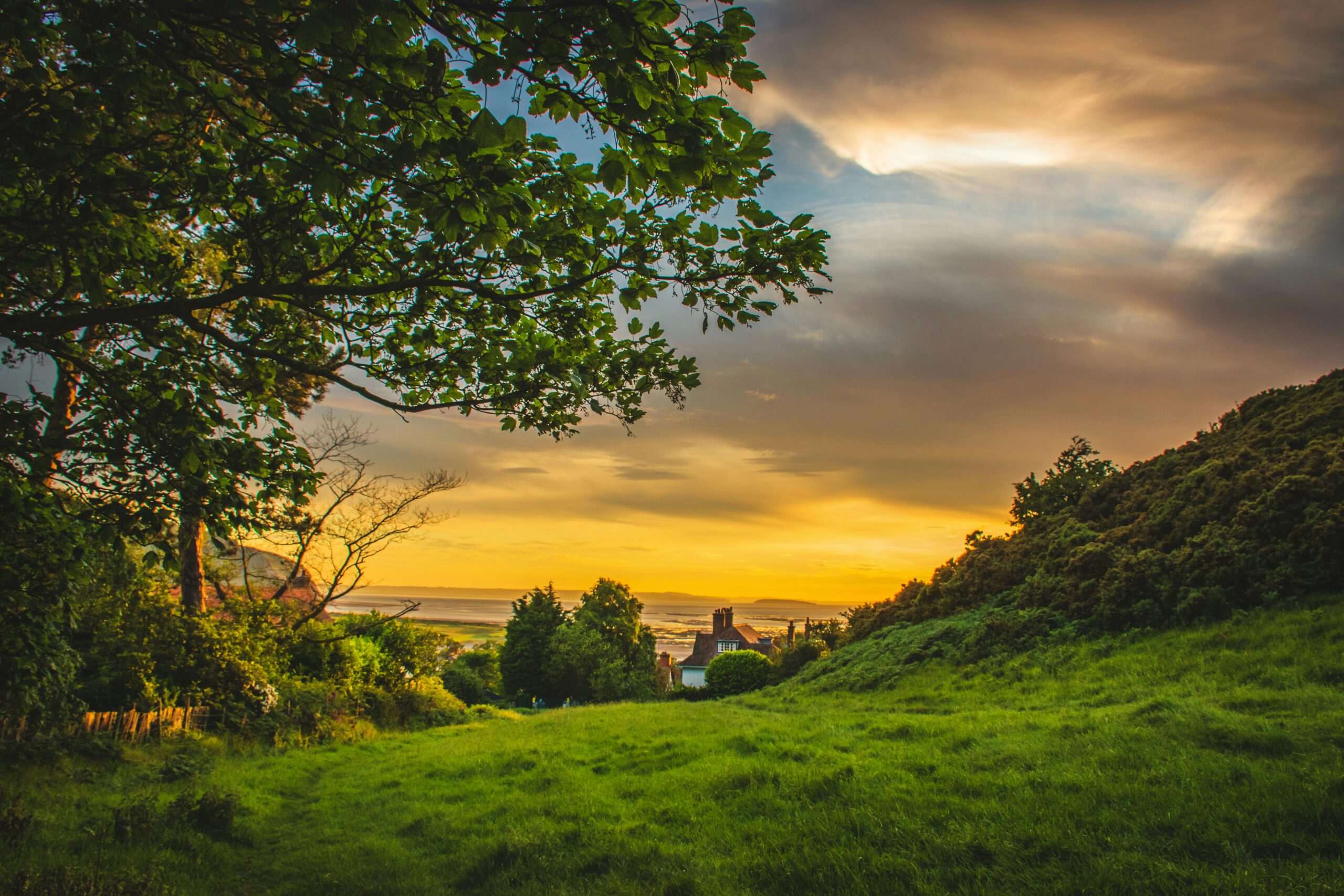 A picturesque sunset over the lush, green countryside of Deganwy, Wales, capturing nature's beauty.