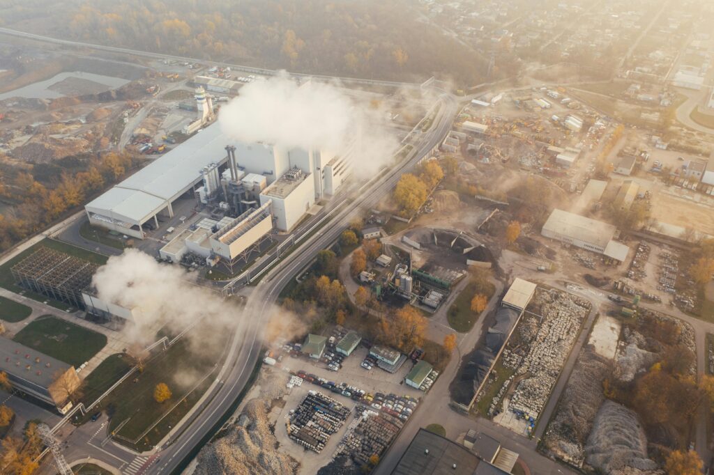 Aerial view showcasing an industrial complex in Poznań, Poland, emitting smoke and steam.